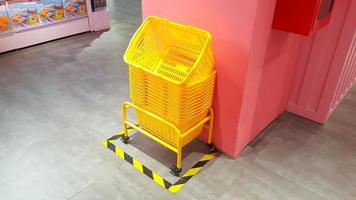 pilha de cestos de compras de plástico amarelo no chão foto