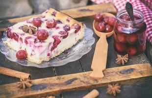 pedaço de bolo de queijo cottage e bagas de cereja foto