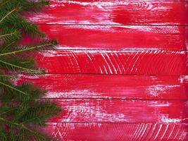 fundo de madeira vermelha com ramos de abeto à direita e um espaço vazio à esquerda foto