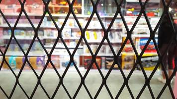 foco seletivo na cerca de arame com fundo desfocado de brinquedos infantis em uma prateleira em um supermercado. cerca de arame. foto