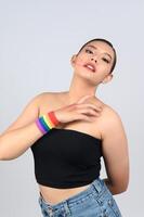 retrato jovem mulher asiática no conceito lgbq com pulseira em fundo branco foto