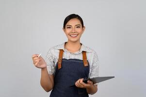 retrato de jovem asiática em pose de uniforme de garçonete com tablet digital foto