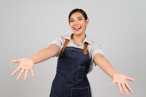 jovem asiática de retrato em uniforme de garçonete com postura de palma aberta foto