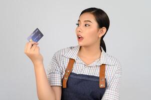 retrato de jovem asiática em uniforme de garçonete pose com cartão de crédito foto