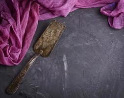 espátula de ferro vintage para sobremesa em uma superfície preta foto