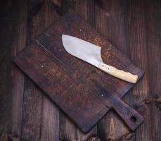 cozinha velha cortando tábua marrom e uma faca para cortar carne foto