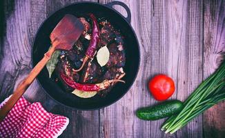 costelinha de porco com especiarias em uma frigideira preta foto