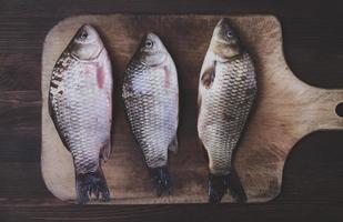 três crucian de rio fresco em uma placa de cozinha foto