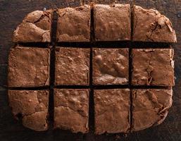 uma torta de brownie de chocolate retangular assada é cortada em quadrados foto