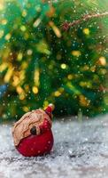 Papai Noel de cerâmica em uma pequena superfície de madeira coberta de neve foto