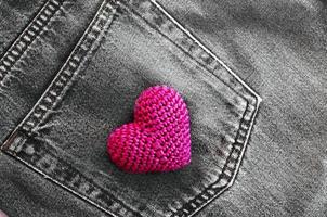 coração de malha vermelho no bolso de trás da calça jeans foto