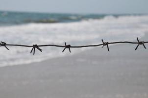 fio de ferro enferrujado contra o mar foto