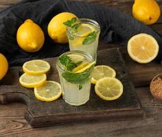 bebida refrescante de verão limonada com limões, folhas de hortelã foto