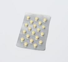 pílulas redondas em blister em um fundo branco, foto