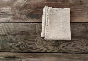 toalha têxtil de cozinha cinza dobrada sobre uma mesa de madeira cinza de tábuas antigas foto