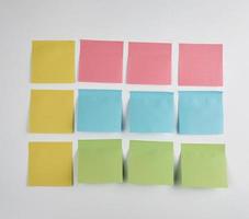 adesivos de papel rosa, azul e verde colados no fundo branco foto