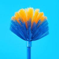 vassoura mop azul-amarela para coletar poeira em uma vara foto