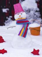 boneco de neve com um balde na cabeça na neve branca foto