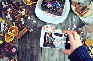 fotografando comida doce em um telefone celular foto