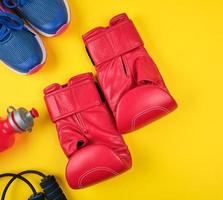 par de luvas de boxe vermelhas e tênis azuis, vista de cima foto