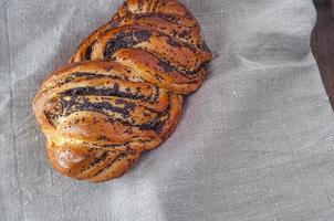 rolo assado com sementes de papoula em um guardanapo cinza foto