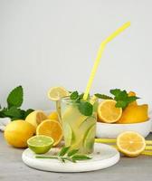 bebida refrescante limonada com limões, folhas de hortelã, limão em um copo foto