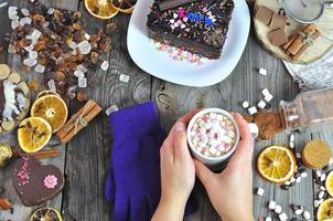 copo com chocolate quente nas mãos femininas foto