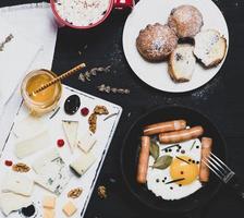 ovo de galinha frito e salsichas em uma frigideira de ferro fundido de louça preta foto