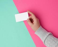 mão feminina segurando o negócio de papel branco vazio foto