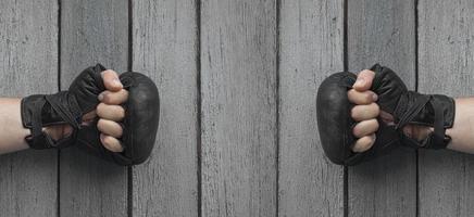 dois homens com as mãos em luvas de couro preto para boxe tailandês foto