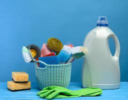 cesta de plástico azul com escovas, esponjas e luvas de borracha para limpeza foto