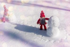 dois homenzinhos de brinquedo rolaram uma bola de neve, dia foto