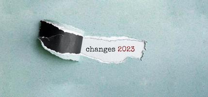 o texto muda 2023 aparecendo atrás de papel verde rasgado foto