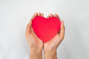 mãos segurando a forma de papel de amor isolada foto