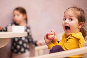 duas irmãs comem deliciosos macarons saborosos de cor doce. foto