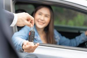 alugar, alugar carro, vender, comprar. o gerente da concessionária envia as chaves do carro para o novo proprietário. vendas, empréstimo de crédito financeiro, aluguel de veículo, seguro, aluguel, vendedor, negociante, prestação, negócio de cuidados com o carro foto