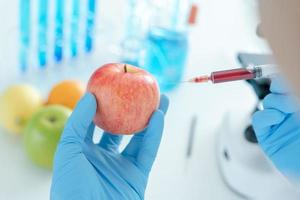 cientista verifica resíduos químicos de frutas em laboratório. especialistas em controle inspecionam a concentração de resíduos químicos. perigos, padrão, encontrar substâncias proibidas, contaminar, microbiologista foto