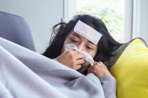 as mulheres asiáticas têm febre alta e coriza. conceito de pessoas doentes foto