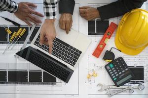 engenheiros e empreiteiros estão discutindo planos de construção de casas. foto