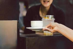 mulher barista servindo xícara de café no café. foto