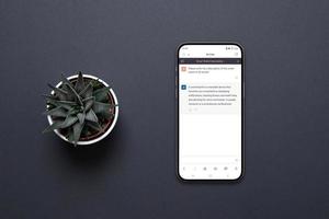 telefone celular na mesa com um aplicativo chatbot ai. projeto conceitual de aplicativo para se comunicar com inteligência artificial. planta ao lado, vista de cima, configuração plana foto