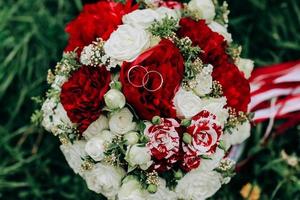 anel de casamento em rosa, você quer se casar comigo. anéis de casamento em um buquê de casamento foto