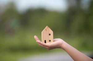 novo conceito de casa - família jovem com modelo em escala de casa dos sonhos nas mãos foto