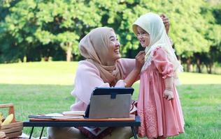 mães e filhas muçulmanas aproveitam as férias no parque. amor e vínculo entre mãe e filho foto