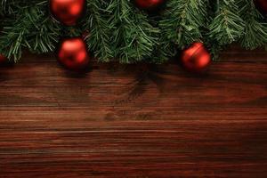 Natal e ano novo com decoração de bolas vermelhas na vista superior do fundo da mesa de madeira com espaço de cópia foto