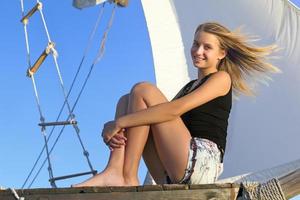 menina adolescente sentada na popa do navio foto