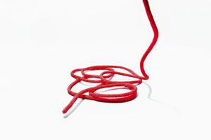único fio de corda vermelha com roll up em um fundo branco. foto