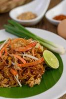 prato de camarão pad thai com limão e ovos foto