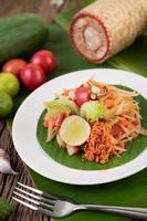 salada tailandesa de mamão com folhas de bananeira e ingredientes frescos foto