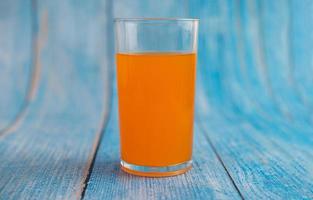 suco de laranja no chão de madeira azul foto